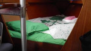 a bunk bed with green and white pillows on it at Velero Freja in Arrecife