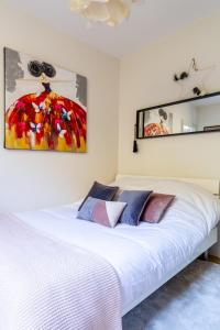 - une chambre avec un lit blanc et une peinture murale dans l'établissement ☆ CHARMANT 2 PIECES, Calme & Lumineux - CENTRE VILLE ☆, à Strasbourg