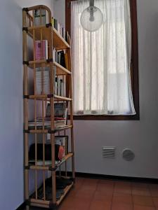 una libreria con libri in una stanza con finestra di b&b Wu Giada a Mestre