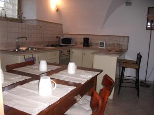 a kitchen with a table and chairs and a sink at APPARTAMENTO AURORA Val di Sogno in Malcesine