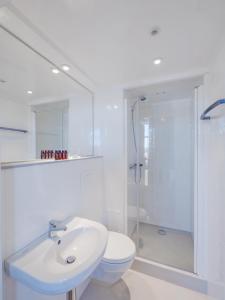 a white bathroom with a sink and a shower at Hamnhotellet in Västervik