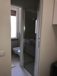 a bathroom with a toilet and a glass shower door at Olivo House 1 in Portovenere