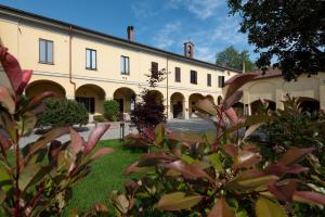 un grande edificio con un cortile con piante di AGRITURISMO CASCINA GRAZIOSA a Cameriano