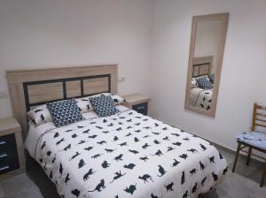 a bedroom with a large bed with black bat pillows at Casa rural El Gato Negro in Trefacio