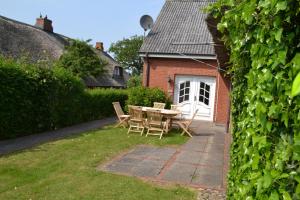 a patio with a table and chairs in front of a house at Dat Strandgood in Oevenum