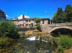 a bridge over a river with a waterfall at Casa rural El Gato Negro in Trefacio