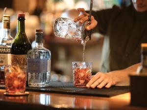 Um barman está a servir uma bebida num copo. em Nobelos Seaside Lodge em Agios Nikolaos
