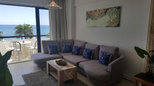 a living room with a couch and a view of the ocean at Sunorama Beach Apartment in Larnaka