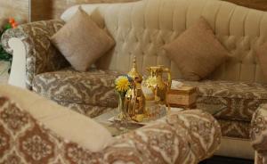 Grand Dahlia Hotel Apartment - Sabah Al Salem في الكويت: غرفة معيشة مع أريكة وطاولة قهوة