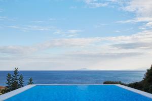 a swimming pool with a view of the ocean at Villa Mare in Skala