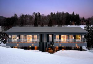 a house in the snow with lights on at STARRY in Hakuba