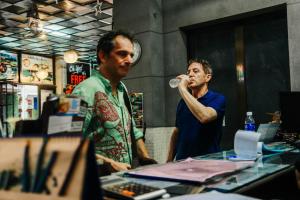 two men standing in a room drinking from a bottle at DMZ Hostel in Hue +62 photos