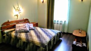 a bedroom with a bed and a table and a window at Гостевой таунхаус in Demidov