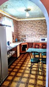 a kitchen with a table and chairs and a brick wall at Гостевой таунхаус in Demidov