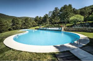 a large swimming pool in the middle of a field at La Holandesa in Cercedilla