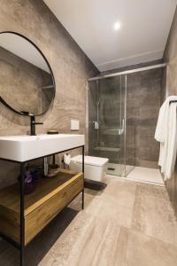 uma casa de banho com um lavatório, um chuveiro e um espelho. em Lofts - Casa do Metro na Póvoa do Varzim