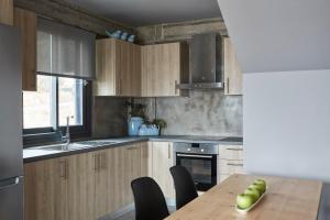a kitchen with wooden cabinets and a wooden table at Villa Sea front in Skala