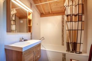 un baño con lavabo y bañera en La Griotte, en Morzine 11 fotos más