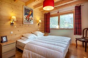 Un dormitorio con una cama grande en una habitación de madera. en La Griotte, en Morzine