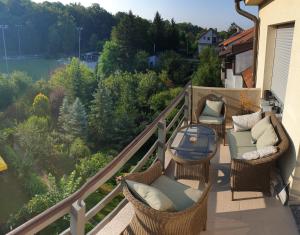 a balcony with wicker chairs and a table with a view at Parkview apartment in Zagreb's favorite neighborhood in Zagreb