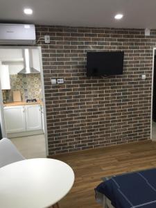 a room with a brick wall with a tv on a wall at Studio Claudia-self Check-in in Brăila
