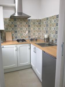 a kitchen with white cabinets and a sink at Studio Claudia-self Check-in in Brăila