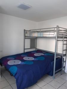 ラ・ロシェルにあるLe Cosy de Tasdonのベッドルーム1室(二段ベッド1組、青いベッドカバー付)