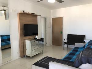 uma sala de estar com uma televisão e um sofá em Lindo Apartamento para Reveillon Copacabana com Vista Mar e Fogos no Rio de Janeiro