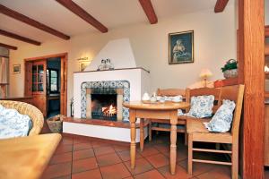 a living room with a table and a fireplace at Landhaus Susewind in Ahrenshoop