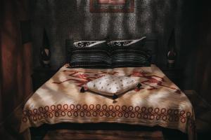 ein Bett mit schwarzen und weißen Kissen darauf in der Unterkunft Manoir Le Refuge in Réchicourt-le-Château
