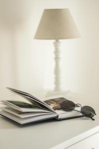 a book with glasses and a lamp on a table at Bed & Breakfast AMATI in Fasano