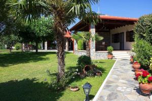 a house with a palm tree in a yard at Giorgio Home - Amazing House 3BD - 400m by the sea in Paralía Skotínis