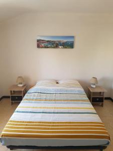 una camera con un letto con due comodini e due lampade di Appartement 62 m2 1er etage avec jardin au rdc a Saint-Génis
