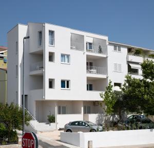 um edifício de apartamentos branco com um sinal de stop em Apartments No 18 em Tučepi