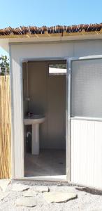 an open door to a bathroom with a sink at Su Pinnetu in Orosei