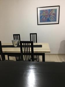 a dining room with a table and chairs and a painting at Alonso 540 Departamento in Río Cuarto