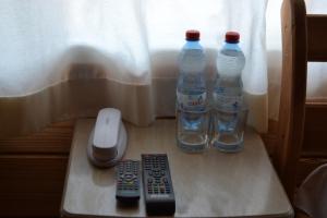 duas garrafas de água e dois comandos à distância numa mesa em Nester House em Svityazʼ