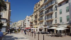 a group of people walking down a street with umbrellas at Citilet 4 Duplex, funky with large terrace in Cannes