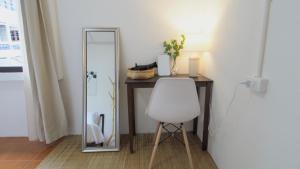 a desk with a white chair and a mirror at Bai Bua House Chatuchak in Ban Zong Katiam