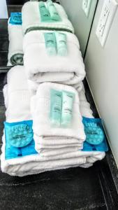 a stack of towels sitting on a shelf in a bathroom at New Urban Modern Main Street House in Vancouver