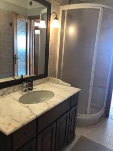 een badkamer met een wastafel, een spiegel en een douche bij Villa sulle nuvole in San Raffaele Cimena