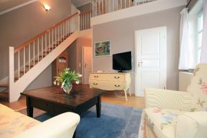 ein Wohnzimmer mit einer Treppe und einem Tisch in der Unterkunft Haus am Kiel in Ahrenshoop
