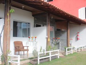 une chaise en bois assise sur la terrasse couverte d'une maison dans l'établissement Pousada Calu, à Cunha