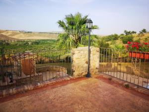 a wrought iron fence with a palm tree in the background at Sperone agriturismo in Assoro