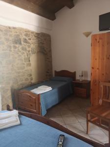 a bedroom with a bed and a stone wall at Sperone agriturismo in Assoro