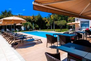 a patio with tables and chairs and a swimming pool at Hôtel Villa Sophia - ADULTS ONLY JULY AND AUGUST in Mougins