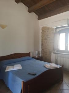 a bedroom with a blue bed with two towels on it at Sperone agriturismo in Assoro