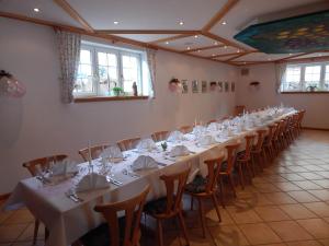 einen langen Tisch mit weißen Tischen und Stühlen in einem Zimmer in der Unterkunft Wein Lodge Durbach - Josephsberg 2 in Durbach