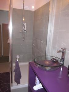 y baño con lavabo de cristal y ducha. en Le Gite de Fanny en Saintes-Maries-de-la-Mer