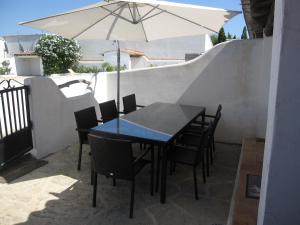 a table and chairs with an umbrella on a patio at Le Gite de Fanny in Saintes-Maries-de-la-Mer